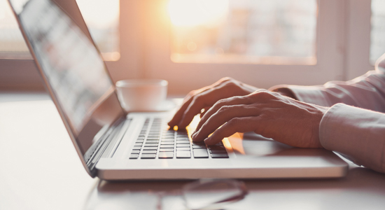 image of hands typing on laptop
